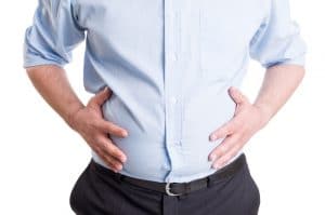 Hands grabbing bloated abdomen. Digestion problem or indigestion, medical concept.